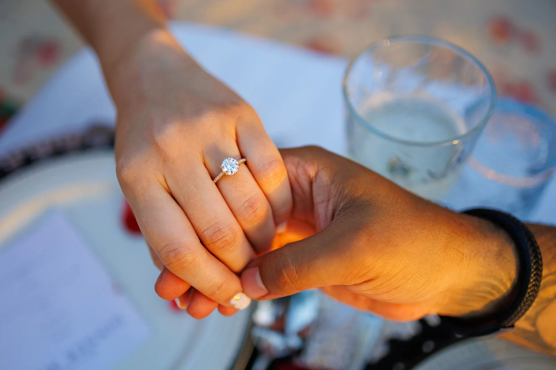 Papagayo Beach Hotel Wedding Close-up of a couple holding hands, highlighting an elegant diamond engagement ring, captured during a romantic moment at Papagayo Beach Hotel Curaçao.