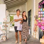 A couple browses colorful souvenirs and locally crafted gifts at Art by Eve boutique in Papagayo Plaza.
