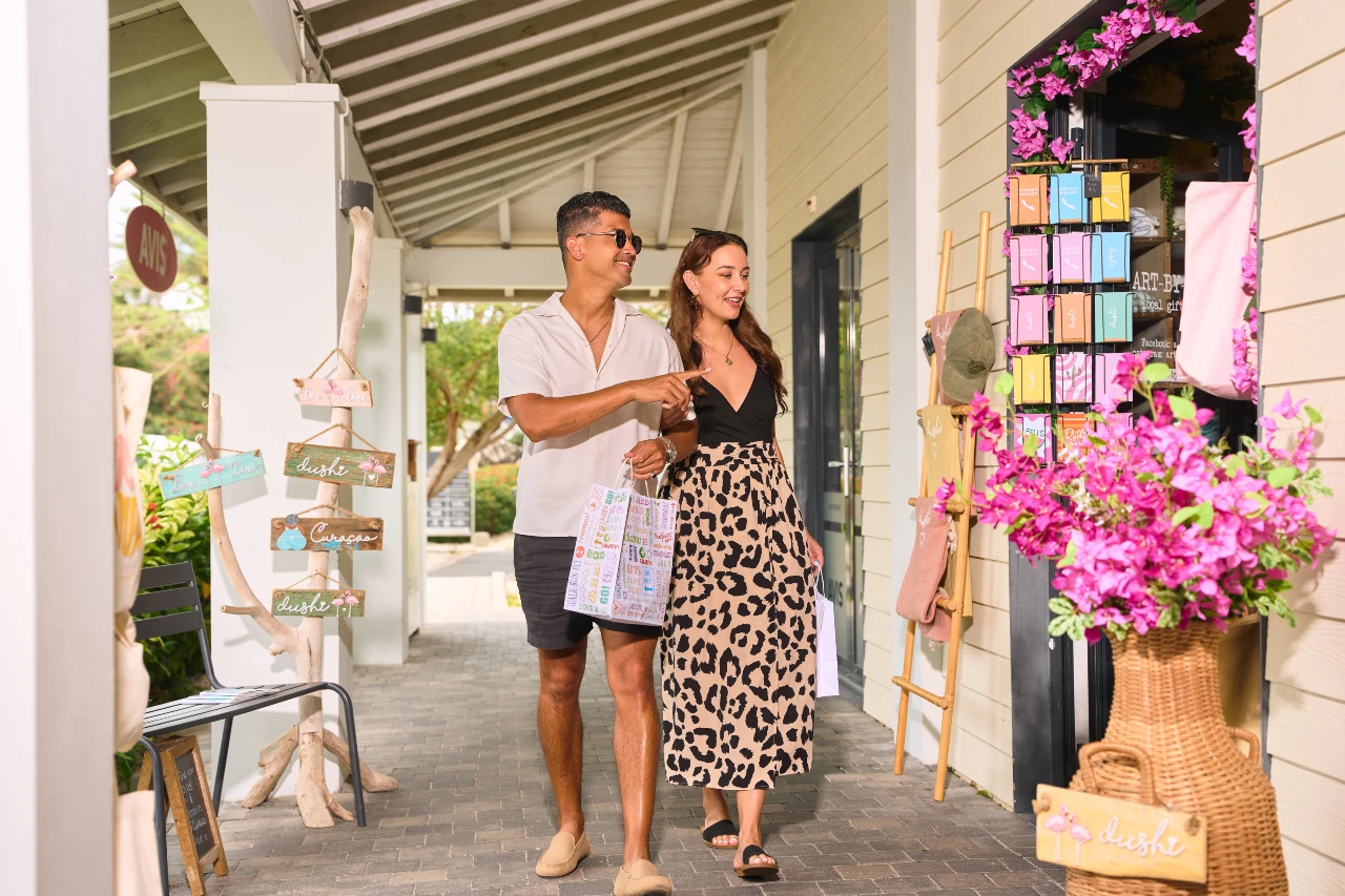 A couple browses colorful souvenirs and locally crafted gifts at Art by Eve boutique in Papagayo Plaza.